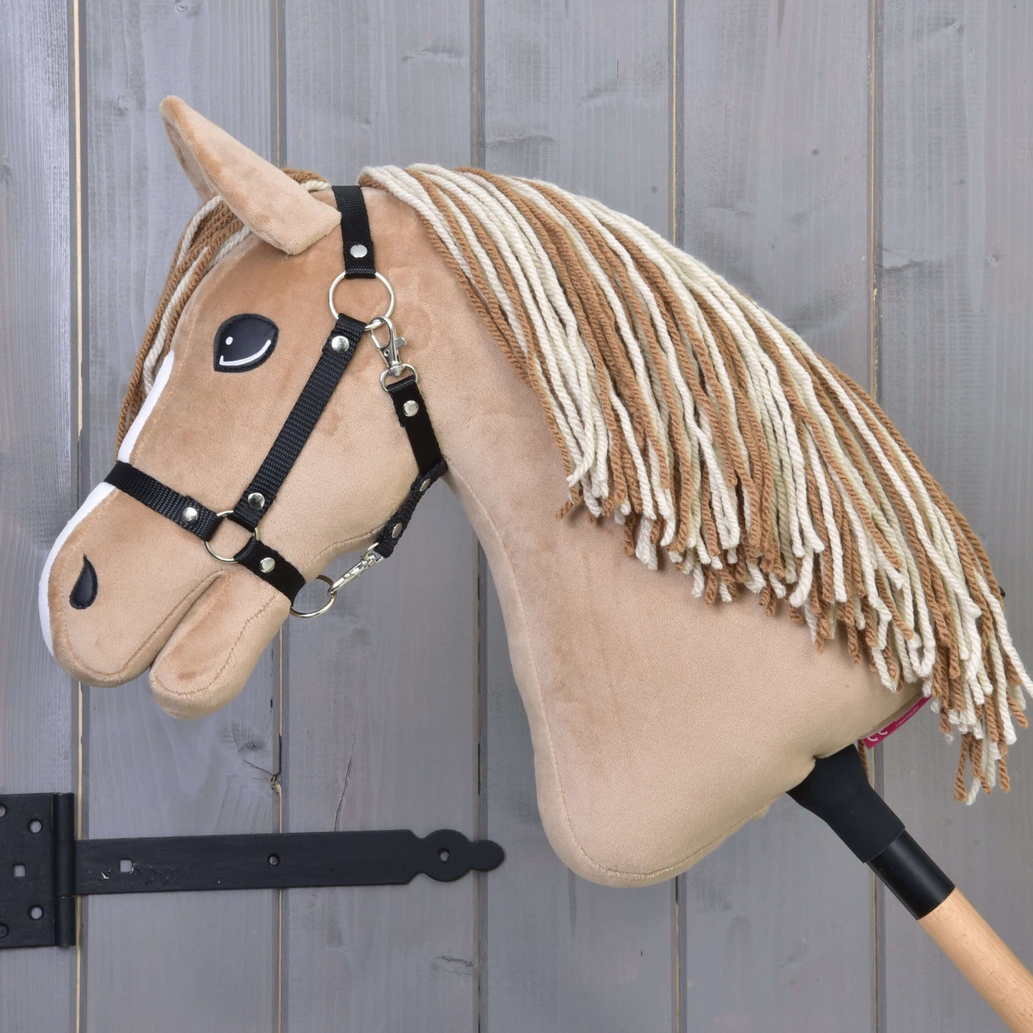 Hobby Horse Bren s černou ohlávkou od Hobby Horse LarDen, s hnědo-krémovou přízovou hřívou, knoflíkovýma očima a na dřevěné tyči – ideální pro fanoušky pasení s American Quarter Horse.