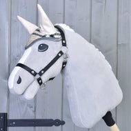 Plyšový šedý Hobby Horse od Hobby Horse LarDen má na sobě čabraku Cremo England a černou ohlávku, je nasazený na dřevěné tyči před světle šedým dřevěným plotem.