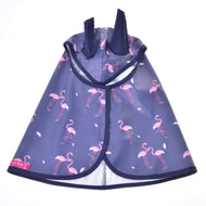 Pláštěnka Flamingo od Hobby Horse LarDen je modrá pláštěnka pro mazlíčky s růžovými plameňáky a dvěma klopami kapuce připomínajícími uši, ideální do každého počasí. Je zobrazená naplocho s otevřenou přední částí a malým štítkem Laz Dera v levém dolním rohu.