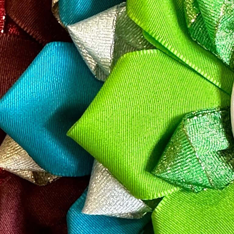 Detail barevných vrstvených mašlí ve zelené, modré, stříbrné a vínové barvě, ideálních pro zdobení Hobby Horse nebo pro oživení vašeho dalšího doplňku pro Hobby Horsing díky jejich lesklé a texturované látce.