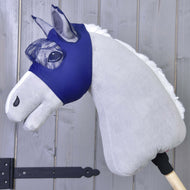 Maska proti hmyzu LarDen od Hobby Horse LarDen zobrazuje plyšového Hobby Horse se světle šedým tělem, bílou hřívou a pratelnou maskou proti hmyzu na dřevěné tyči, na pozadí dřevěných panelů.
