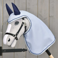 Pláštěnka Luméa od Hobby Horse LarDen na plyšovém šedém Hobby Horse s černou uzdečkou, modrou pláštěnkou a tmavě modrými kryty uší, zobrazená na světlem dřevěném pozadí.