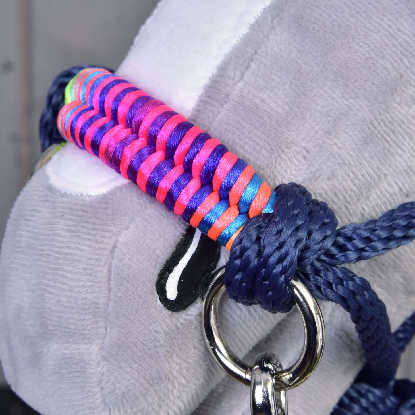 Provazový set Rosemary od Hobby Horse LarDen, detail obličeje plyšového zvířete s výraznou vícebarevnou pletenou ohlávkou, modrými provazovými otěžemi a lesklým kovovým kroužkem na boku.