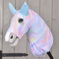 Hobby Horse ochranný oblek Rainbow od Hobby Horse LarDen s plyšovým potahem v pastelových duhových barvách, modrýma ušima, usměvavou tváří a knoflíkovýma očima, nasazený na tyči na pozadí světlého dřeva.