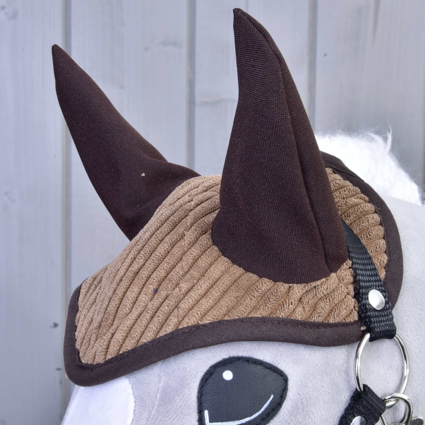 Set Manchester Le Chocolate od Hobby Horse LarDen, detail plyšové hračky s hnědou žebrovanou čabrakou, tmavě hnědýma ušima, bílým obličejem, černou uzdečkou a jednoduchým vyšívaným okem – perfektní jako půvabná dekorace koně.