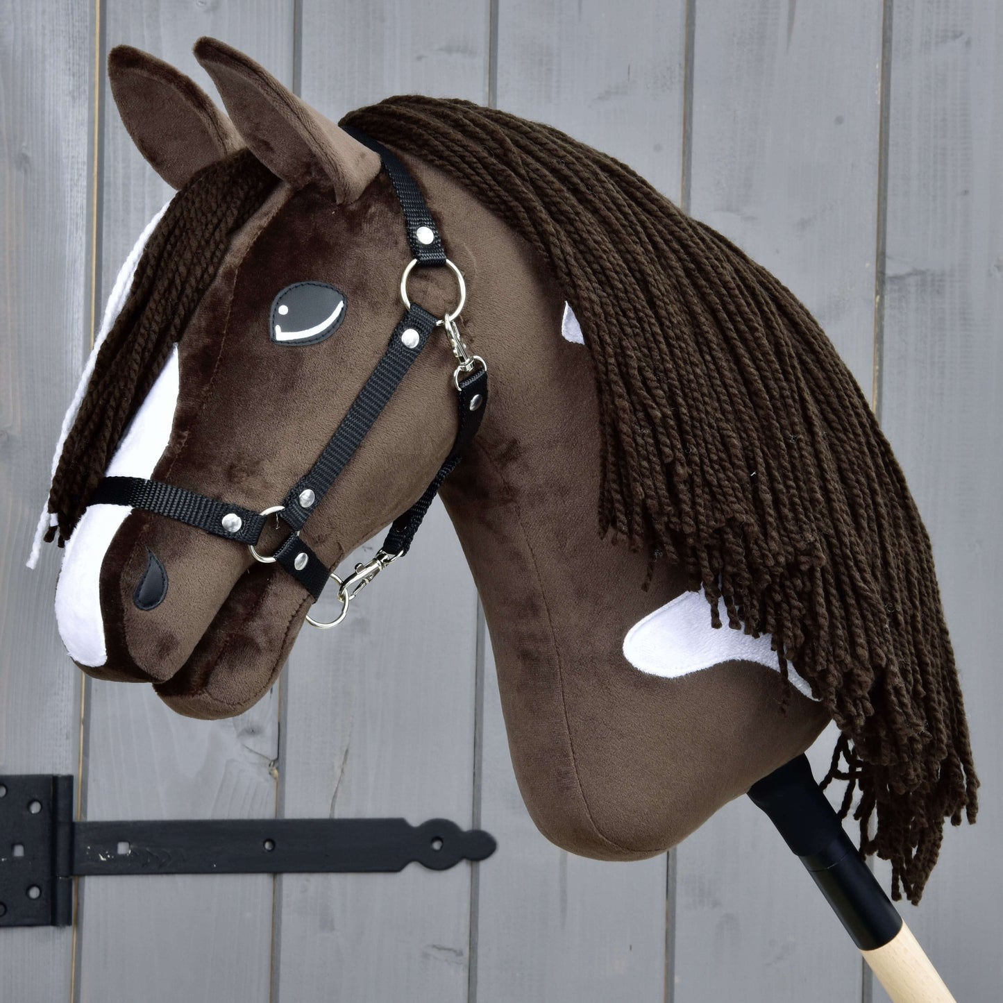 Hobby Horse Monte s černou ohlávkou od Hobby Horse LarDen má hnědobílý design inspirovaný American Paint Horse, černou ohlávku, bílé skvrny, dlouhou tmavou přízovou hřívu a je upevněný na dřevěné tyči.