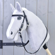 Šedý plyšový Hobby Horse s bílou lysinou, s Kompletní uzdečka bez nánosníku Pure Black od Hobby Horse LarDen, nasazený na dřevěné tyči na světle šedém dřevěném pozadí.