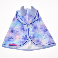Pláštěnka Space od Hobby Horse LarDen s pastelovým galaktickým vzorem, malými bílými hvězdami, fialovým lemem a jemně světle modrými jednorožčími ušima. Tento hravý pláštík slouží také jako pláštěnka pro Hobby Horse – ideální do vaší sbírky doplňků pro Hobby Horse.