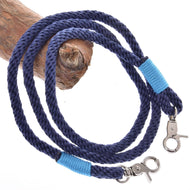 Provazový set Dark Blue od Hobby Horse LarDen obsahuje stočené tmavě modré vodítko s kovovými karabinami na obou koncích, každou omotanou jasně modrou nití, a je vystavené na světle hnědé dřevěné větvi – stylový jezdecký doplněk.